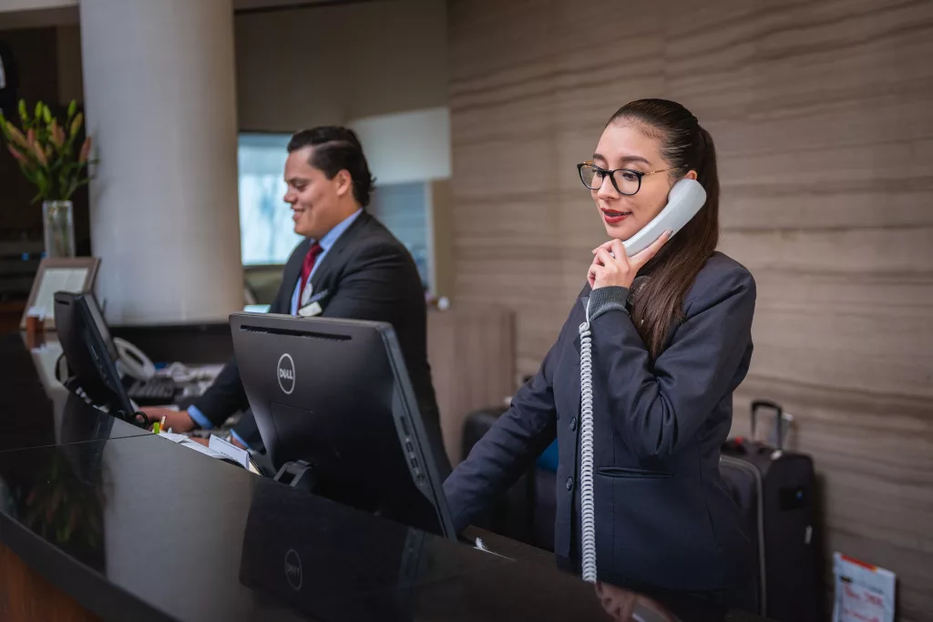 two receptionists in a  hotel answering calls on the phone